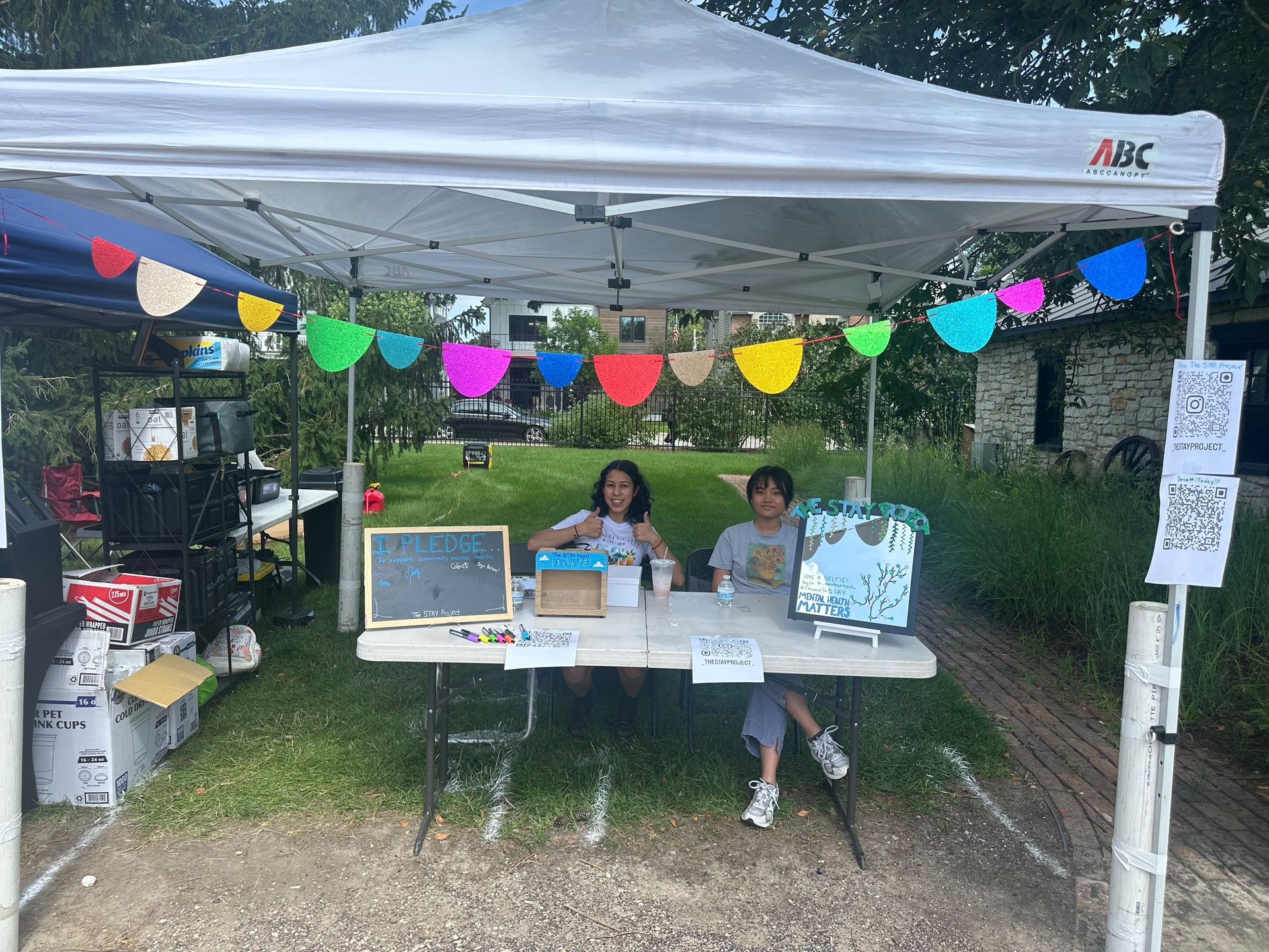 Volunteers staffing The STAY Project's booth at the Naper Settlement Farmers Market