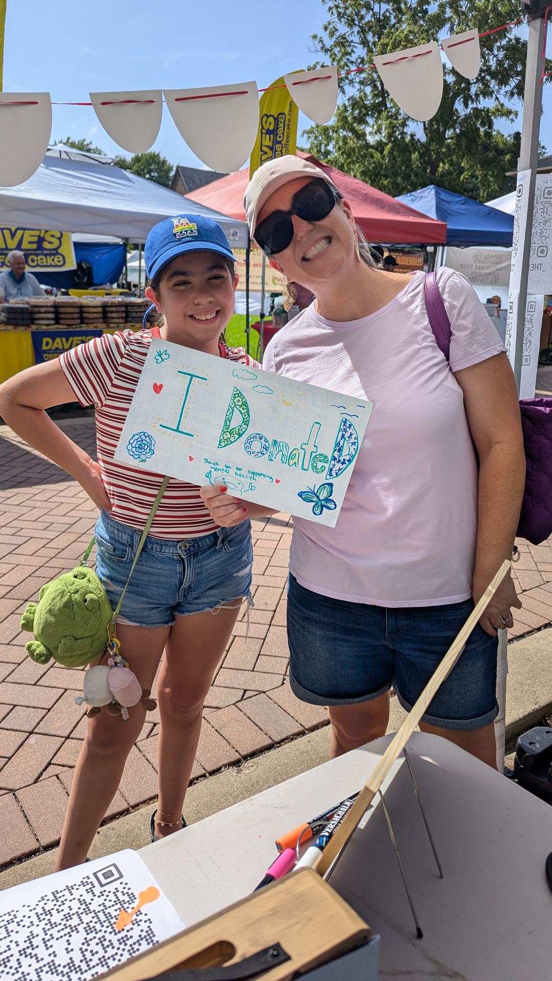 A parent and child holding an 'I donated' sign together