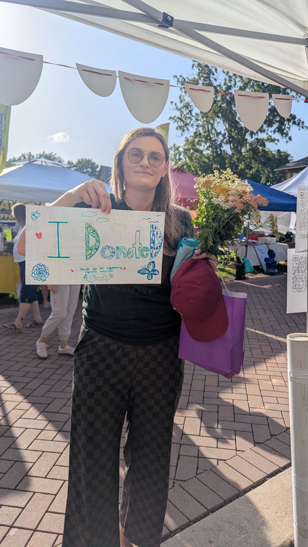 A supporter holding an 'I donated' sign at a STAY Project drive