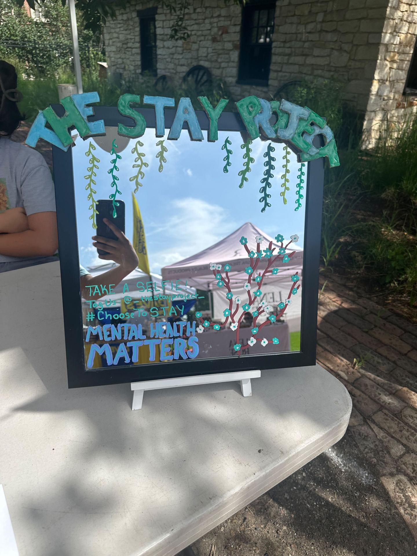 Hand-painted mirror at The STAY Project booth reading Mental Health Matters