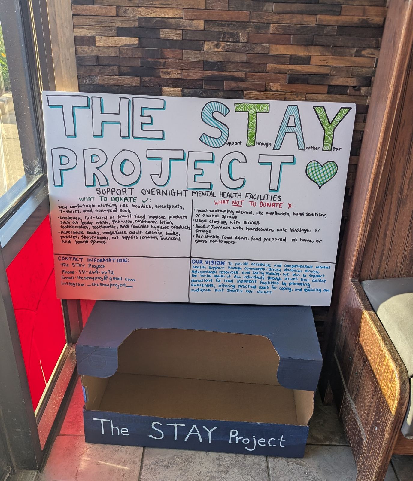 Donation drive collection box with an informational poster