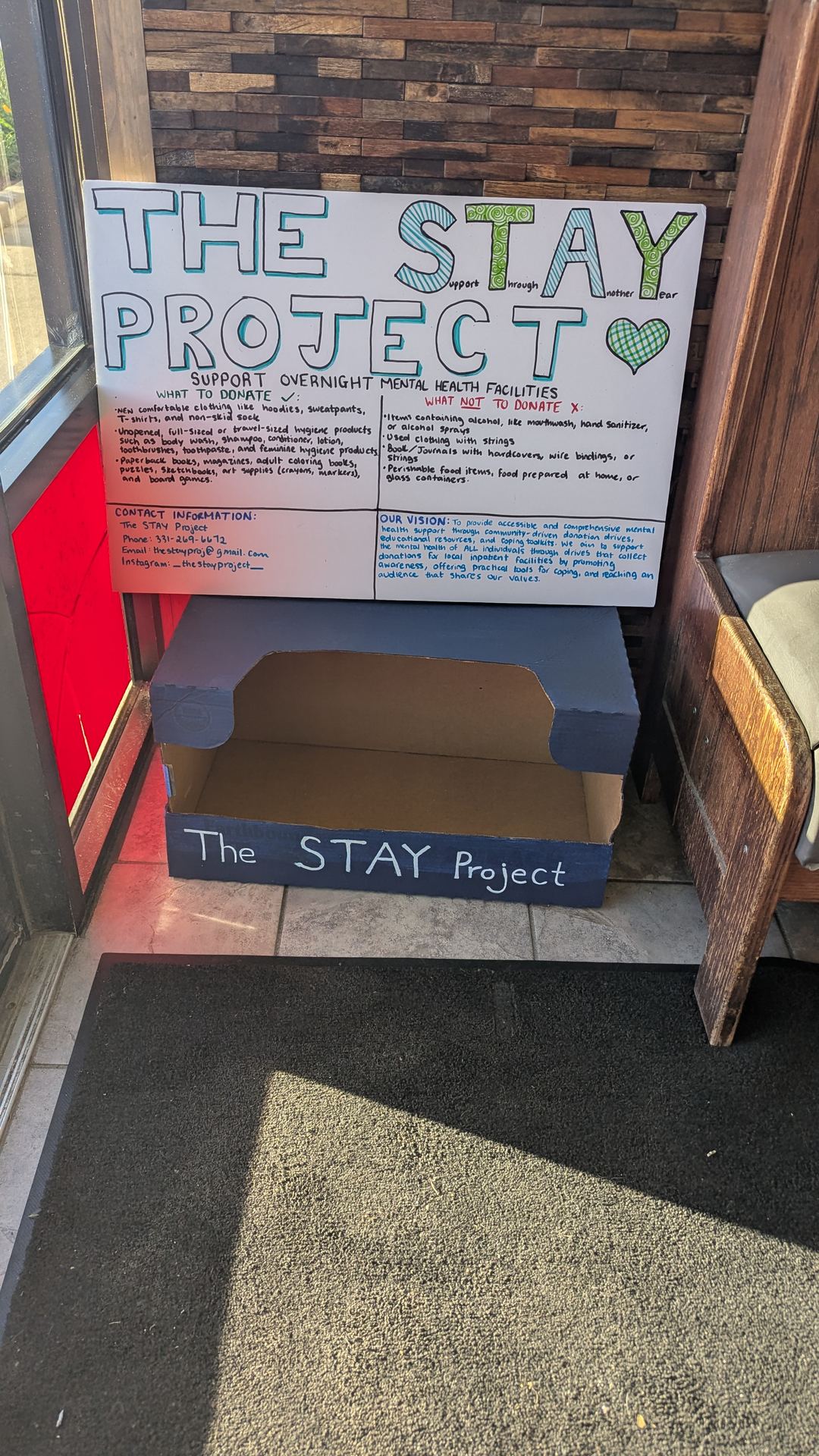 Donation drive collection box with an informational poster